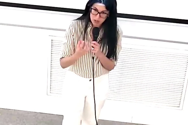 ד״ר מאיה שפיגל מרצה עם מיקרופון באולם הרצאות